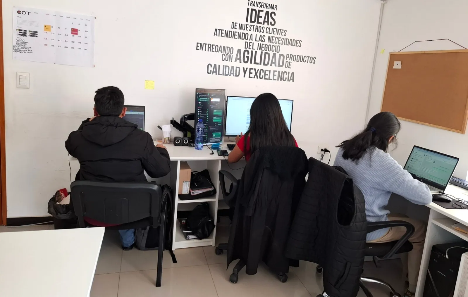 Equipo de diseño web y contenido de Cusco Creativos trabajando bajo el mural de la marca