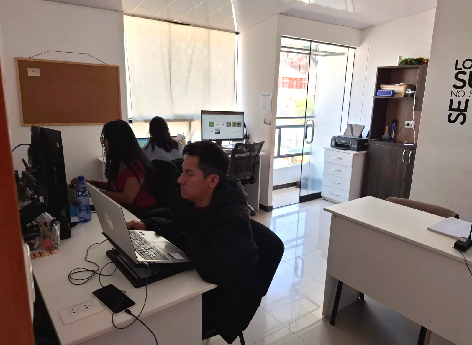 Equipo de Cusco Creativos trabajando en sus computadoras en la oficina de Cusco