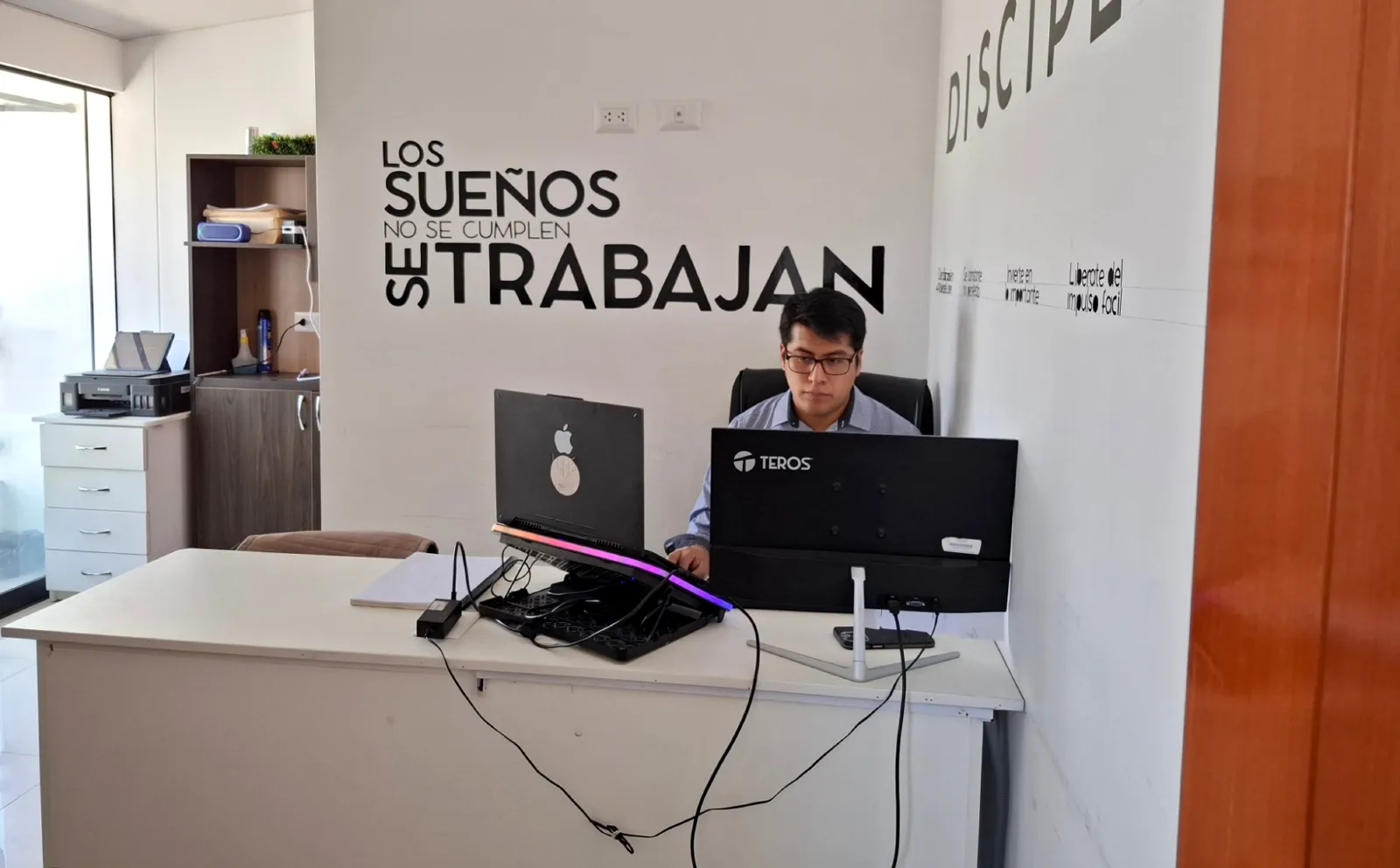Escritorio de desarrollo en la oficina de Cusco Creativos con el lema «Los sueños no se cumplen, se trabajan»