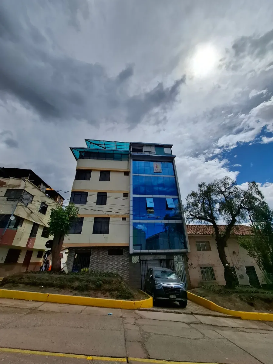 Edificio de vidrio azul con el logo de Cusco Creativos en Clorinda Matto de Turner D-21, Cusco