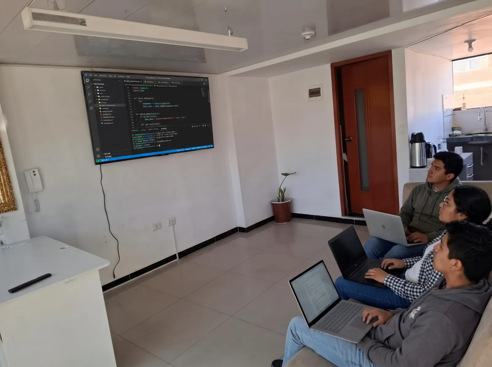 Sala de capacitaciones de Cusco Creativos en Cusco: grupo con laptops frente a la TV durante un taller