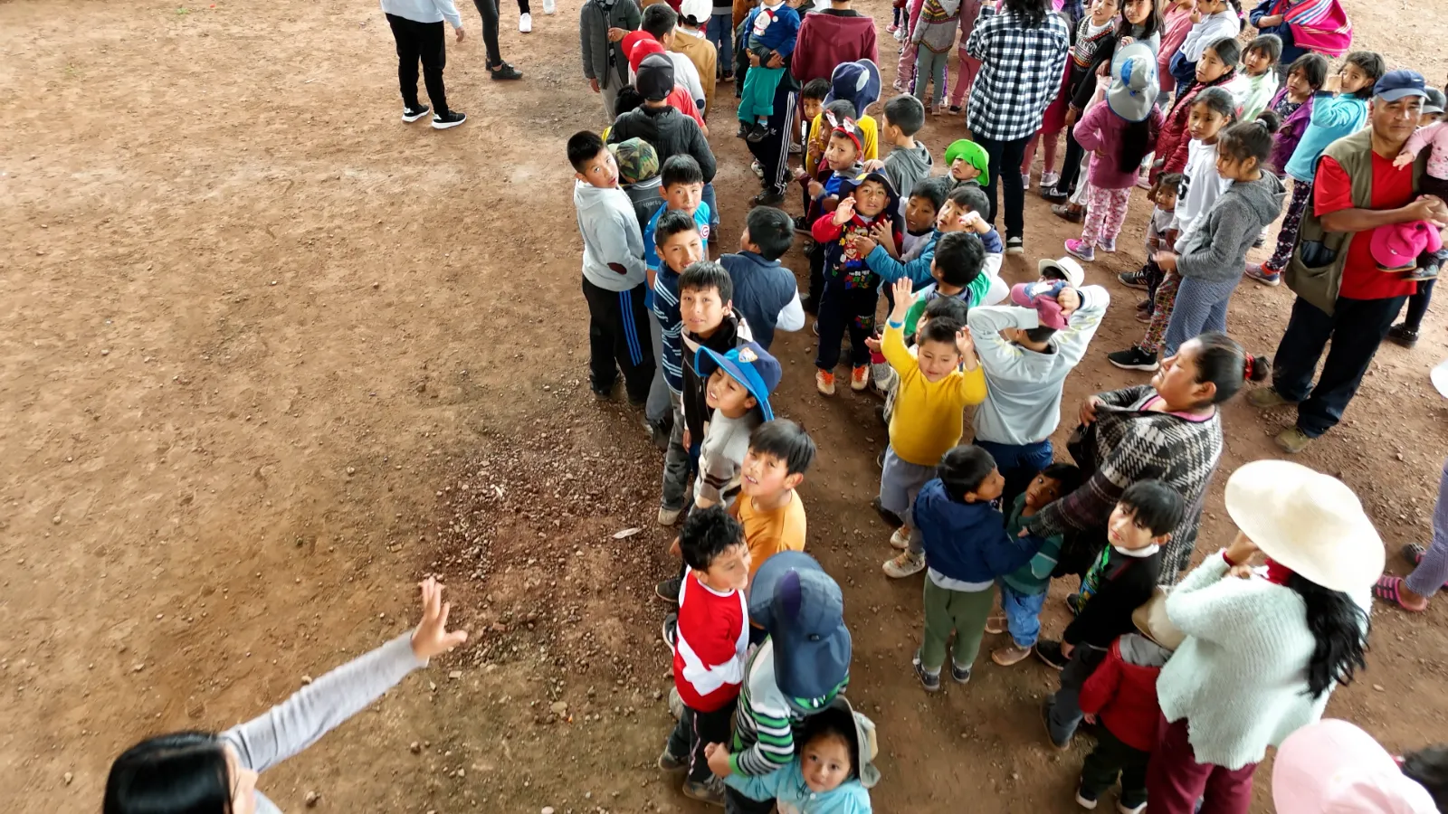Vista desde arriba de los niños haciendo fila en la losa deportiva del distrito de Santiago