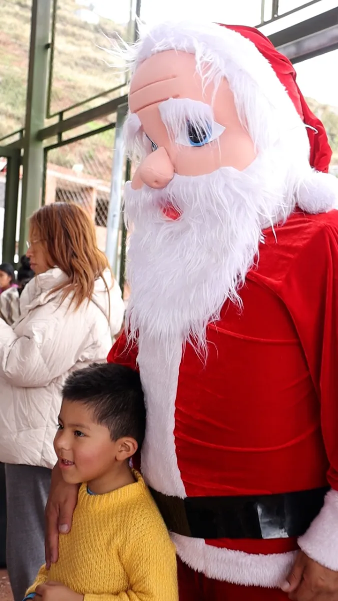 Un niño posa junto a Papá Noel en la Navidad 2023 organizada por Cusco Creativos
