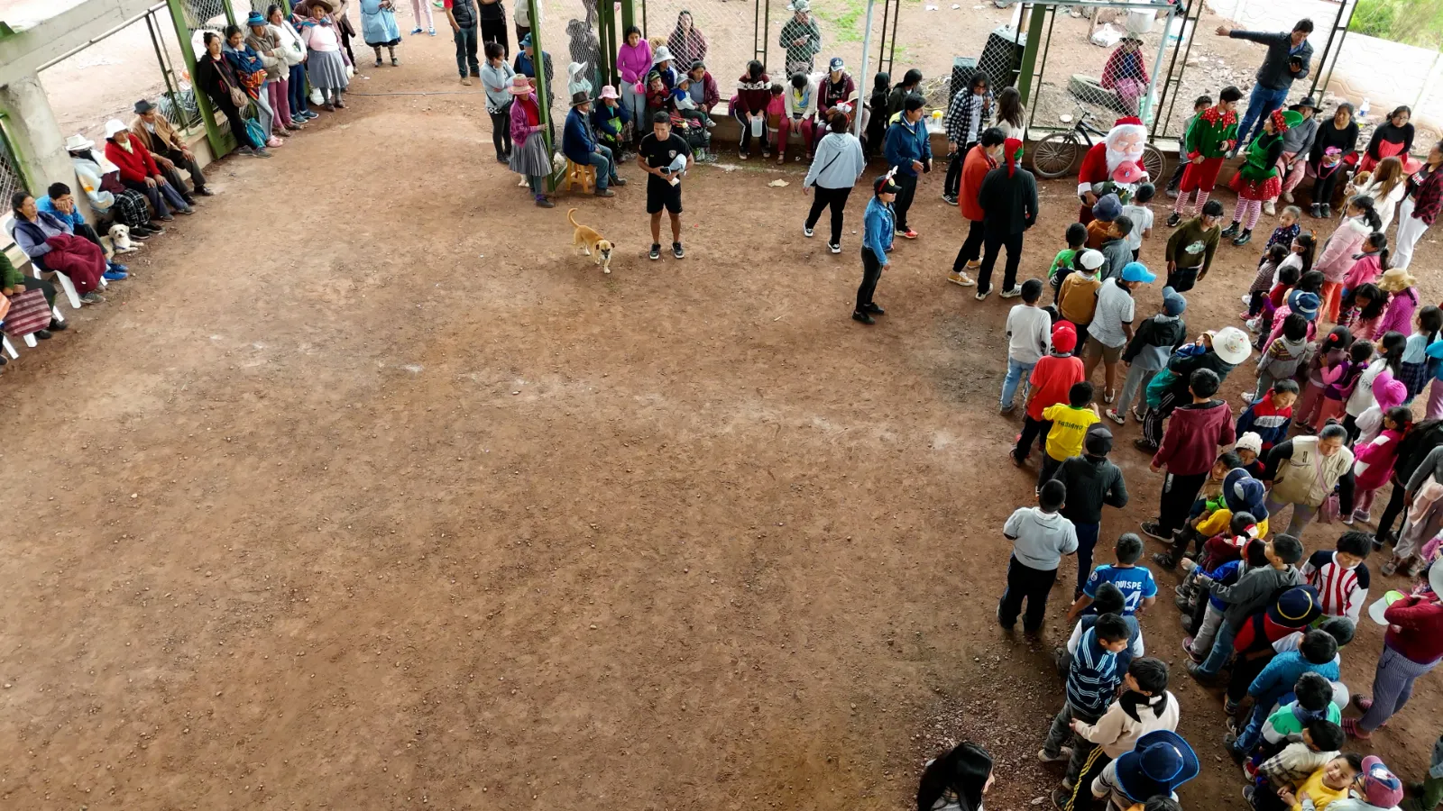 Niños y familias reunidos en la losa deportiva techada durante la actividad navideña