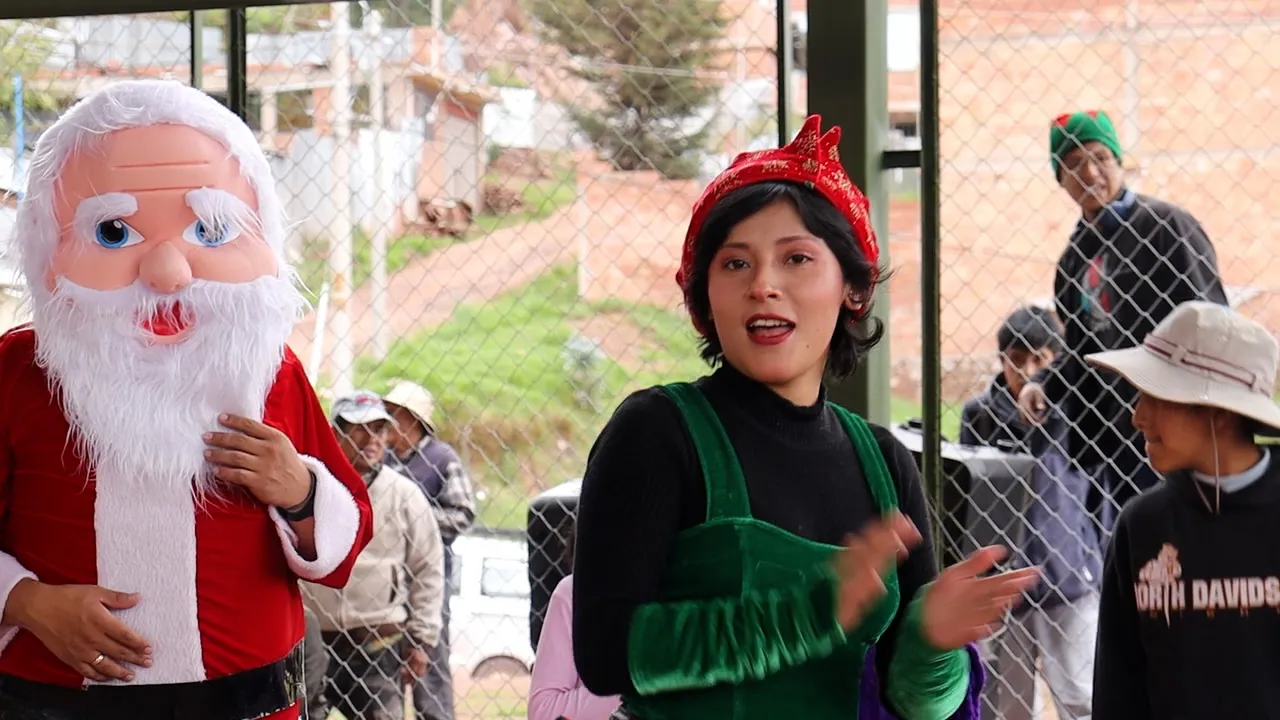 Papá Noel y una duende saludan a los niños durante la Navidad 2023 de Cusco Creativos en el distrito de Santiago, Cusco