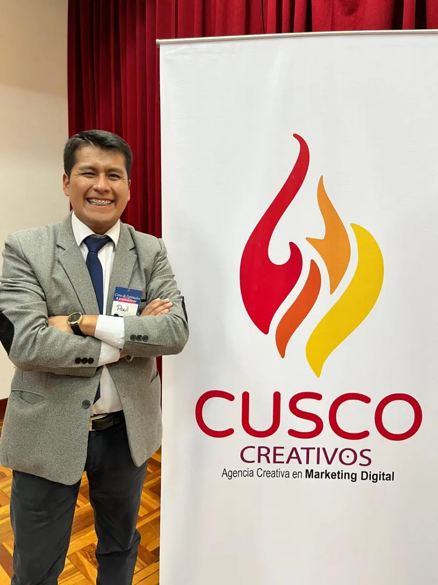 Paul Pumalloclla, gerente de Cusco Creativos, junto al banner de la agencia en un evento