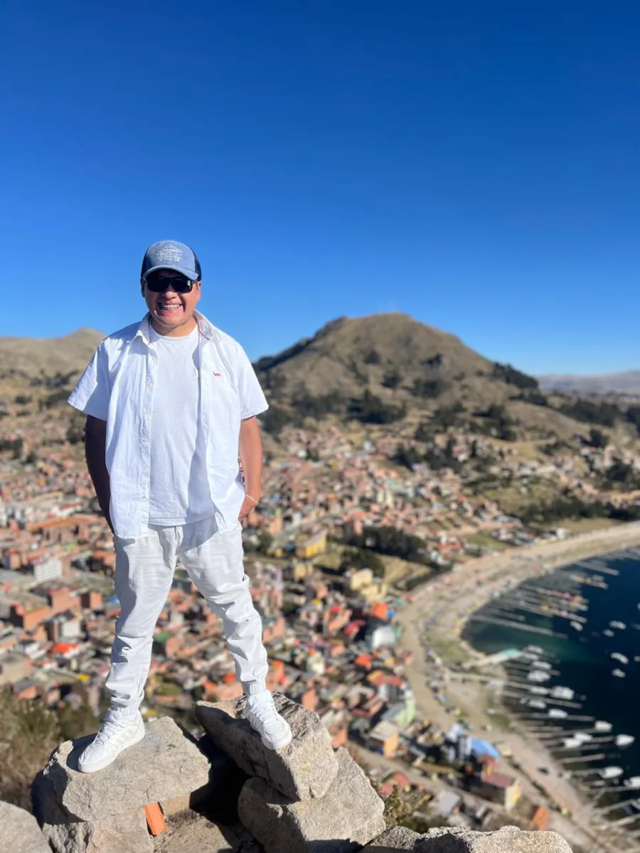 Paul Pumalloclla en un mirador sobre Copacabana y el lago Titicaca