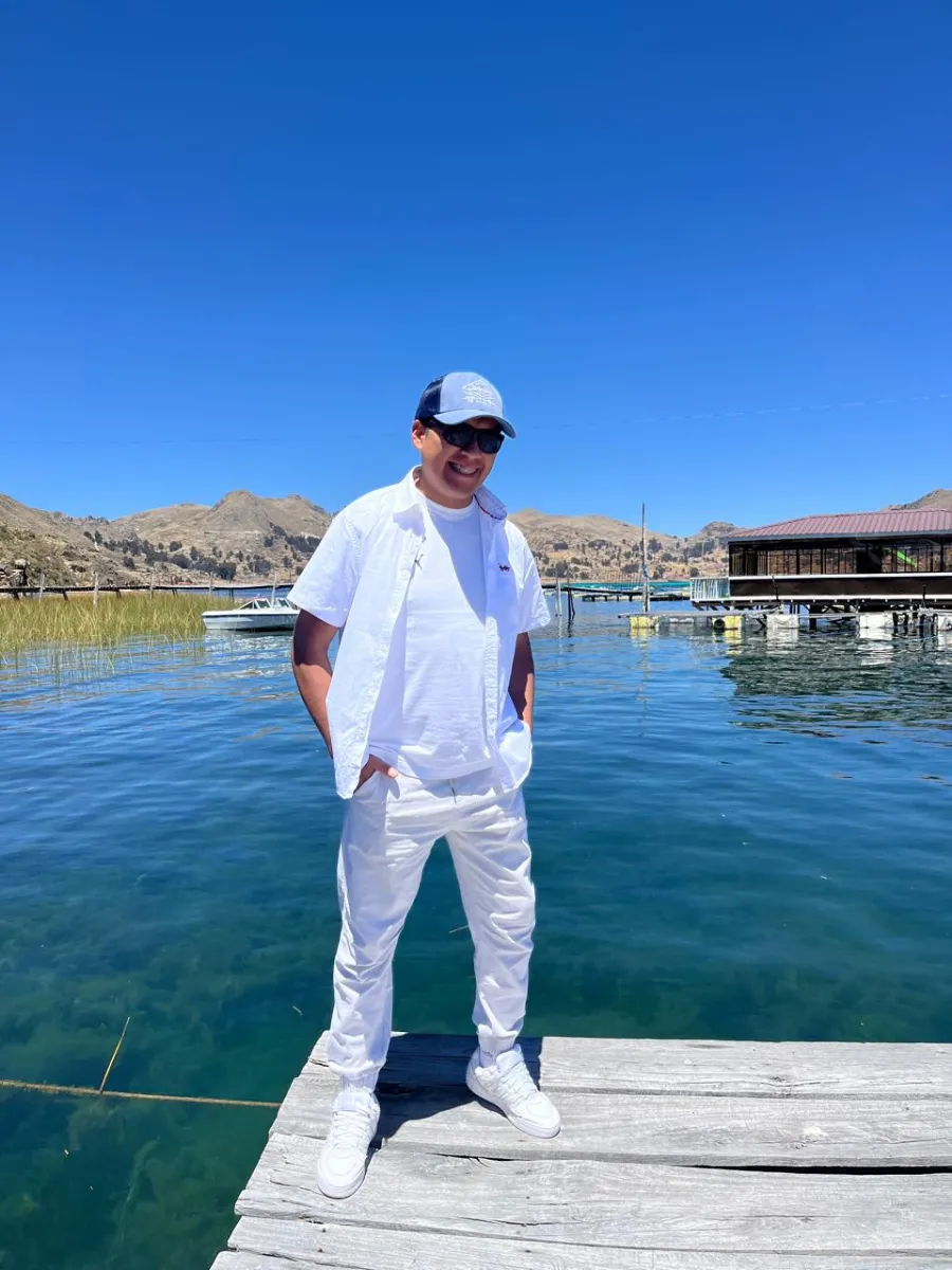 Paul Pumalloclla sonriendo en un muelle de madera del lago Titicaca