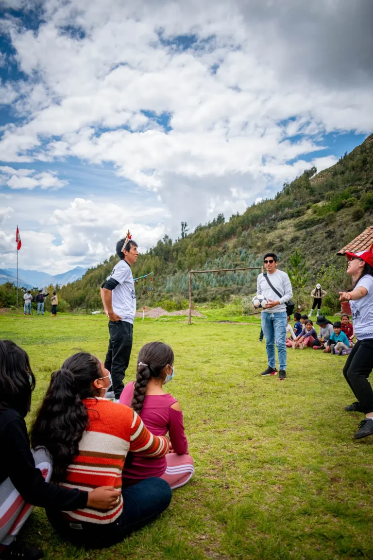 Integrantes de Cusco Creativos dirigen juegos con pelota en la cancha de la comunidad